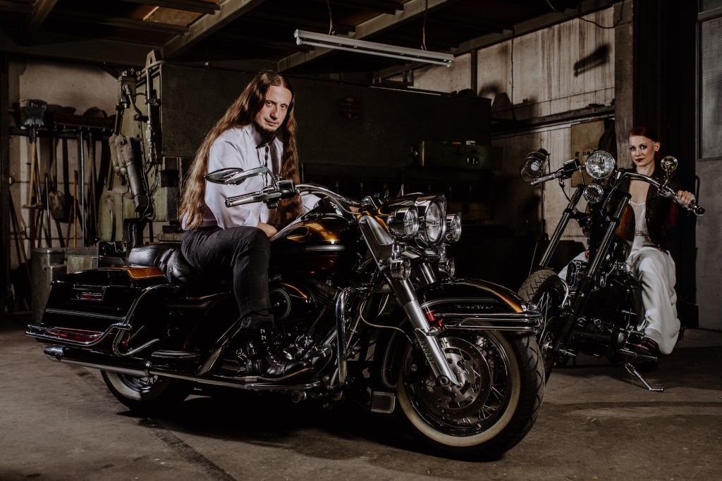 Rocker-Bräutigam mit langen Haaren auf Harley